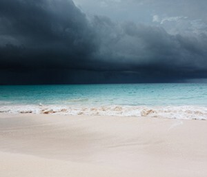 image of a beach with dark storm clouds approaching 